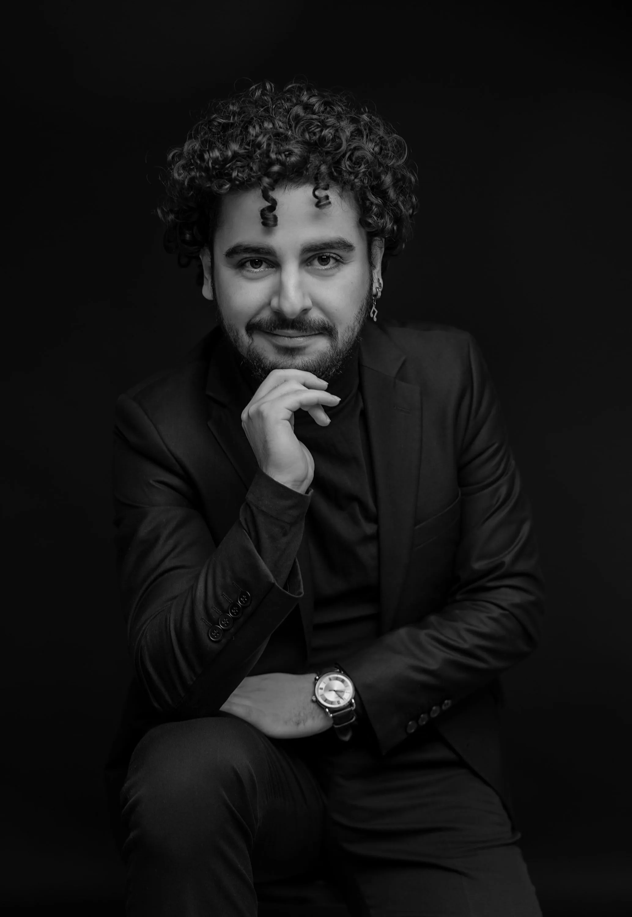 Zekeriya Türkmen in a dark jacket, resting his chin on his hand, black-and-white portrait